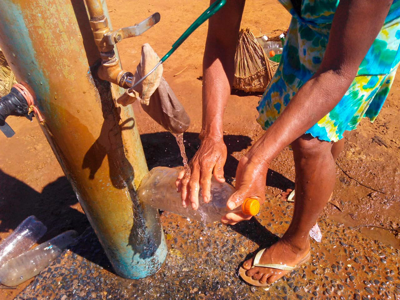 Indígena pegando água em poço