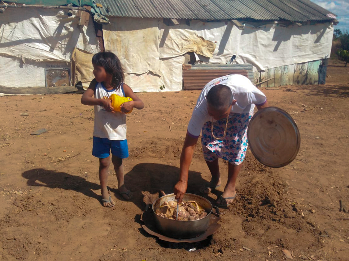 índios cozinhando no chão da aldeia