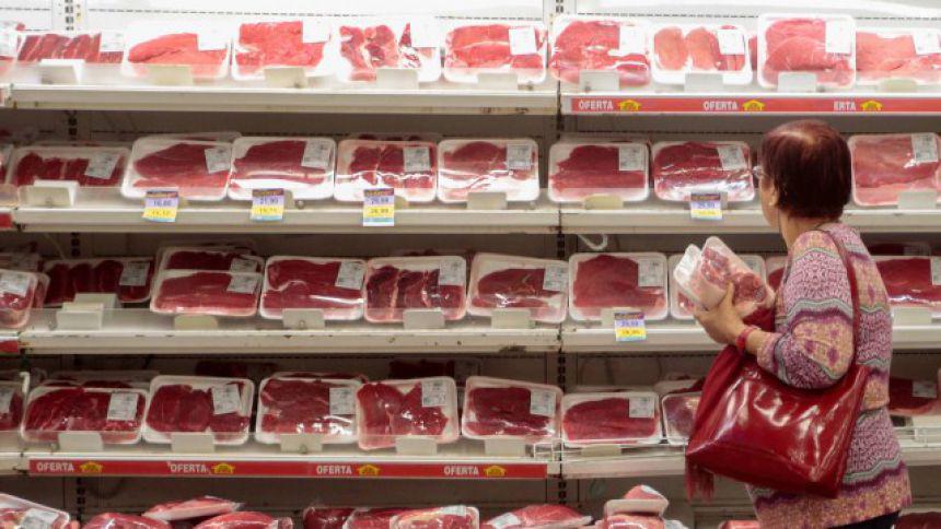 Consumidora analisa cortes de carne bovina em supermercado
