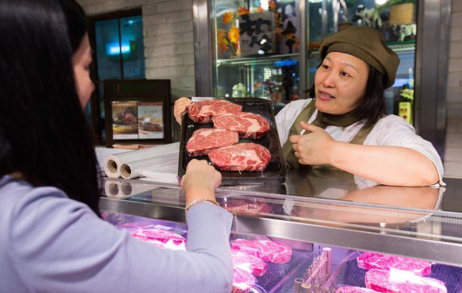 Vendedora em loja de carne bovina na China, carnes