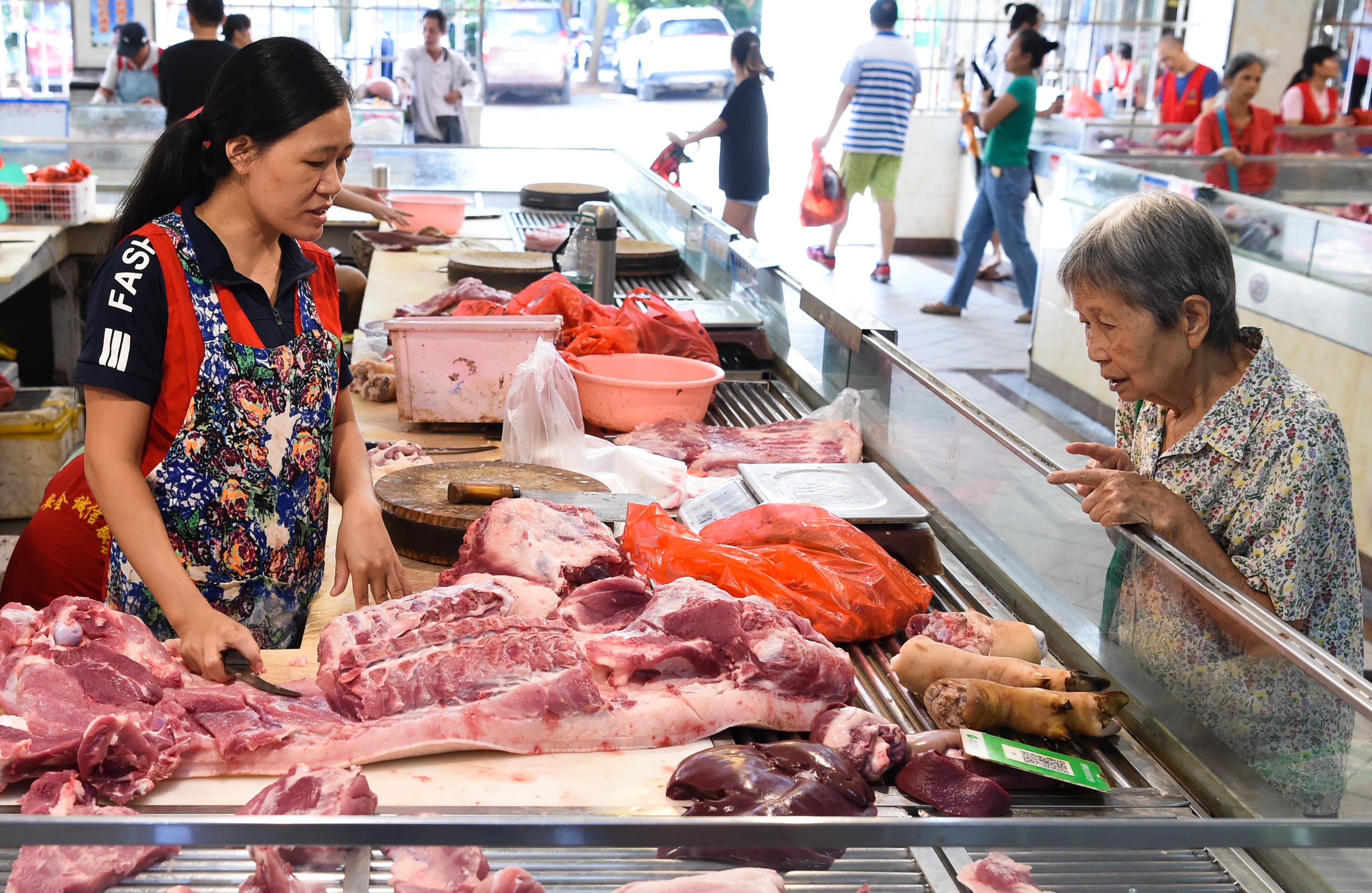 Idosa faz compras em mercado de carnes da China