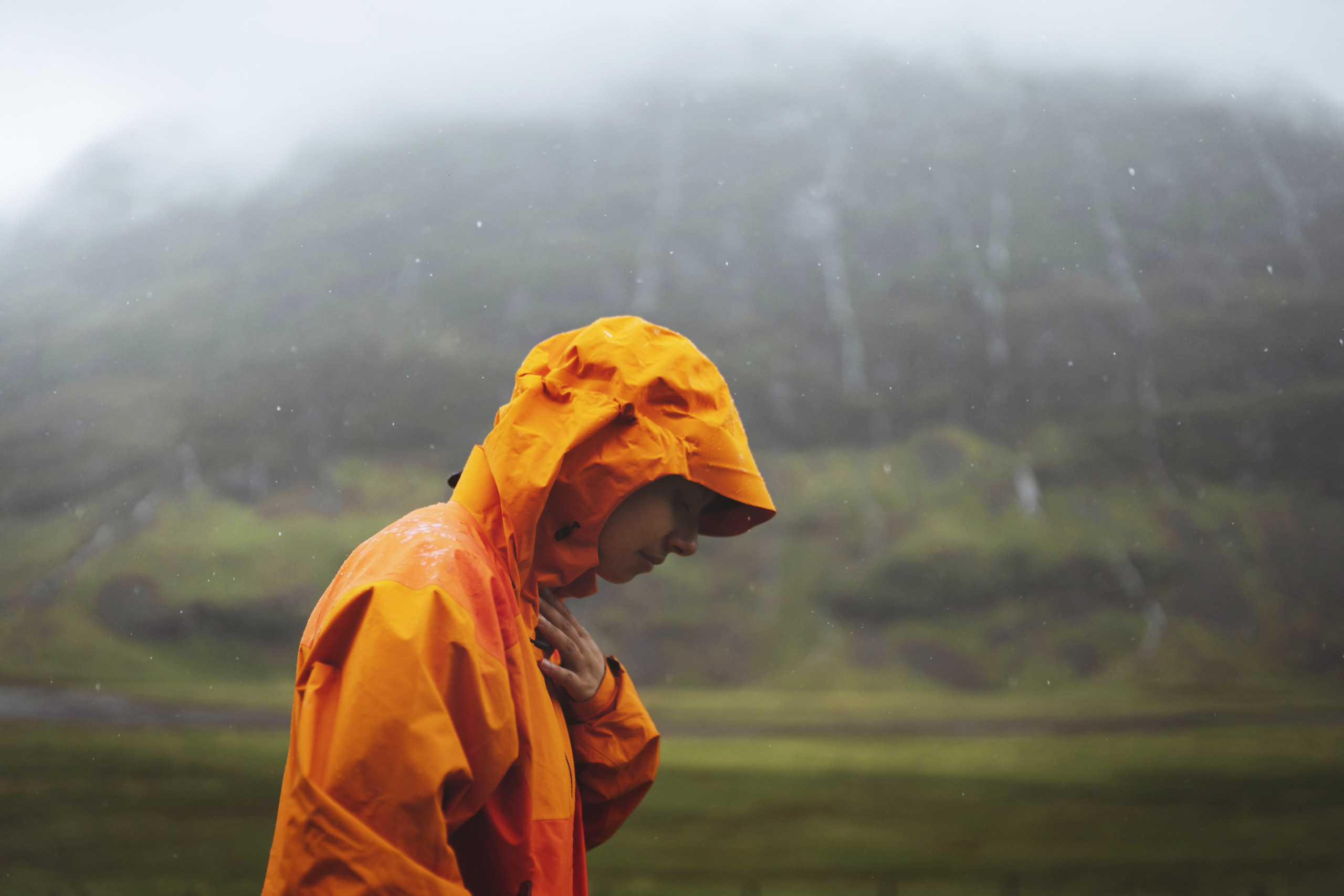 pessoa usando capa em chuva causada por frente fria
