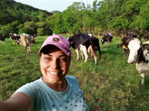 produtora de leite com vacas ao fundo