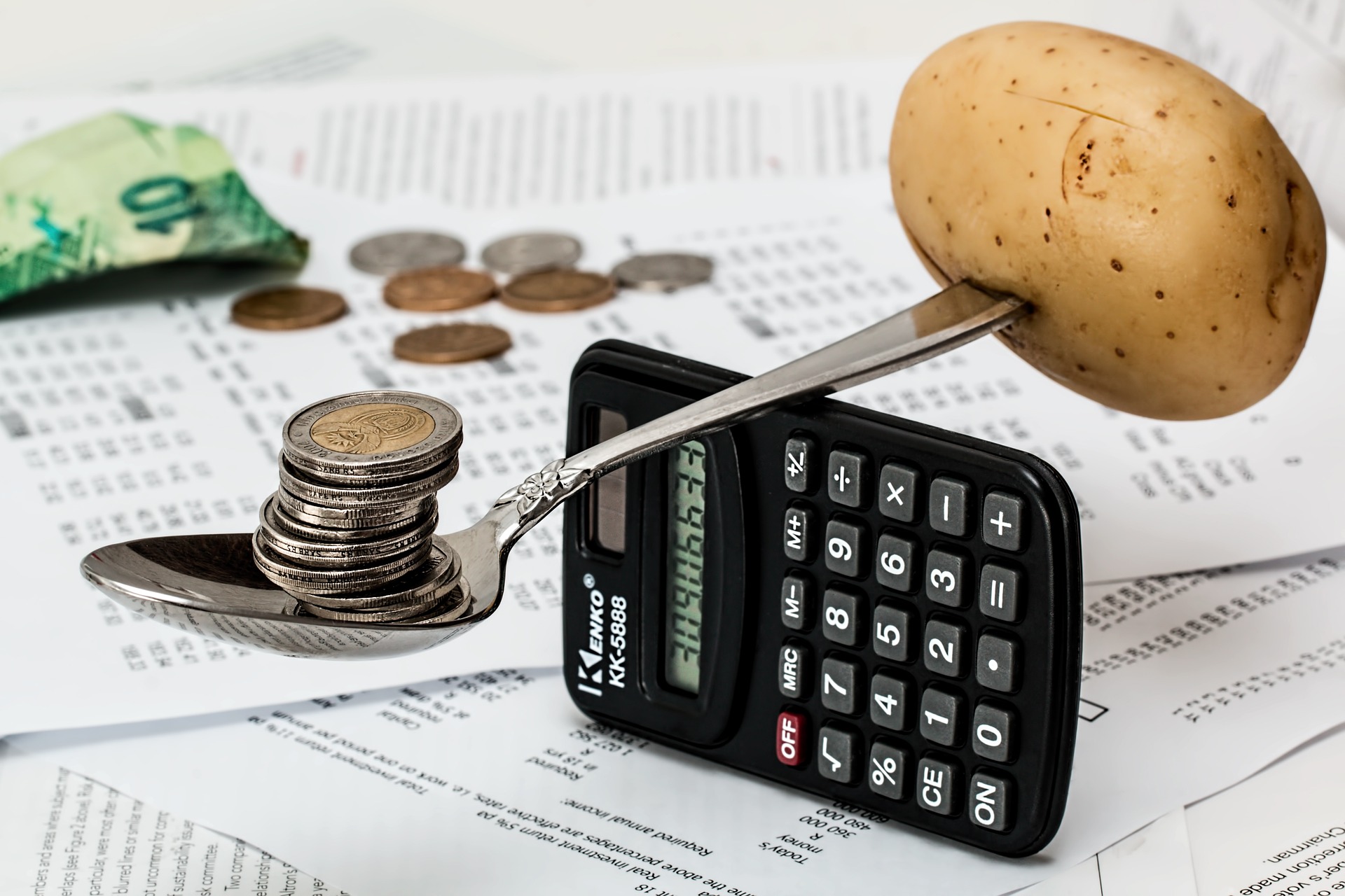 batata equilibrada em calculadora. moedas do outro lado.