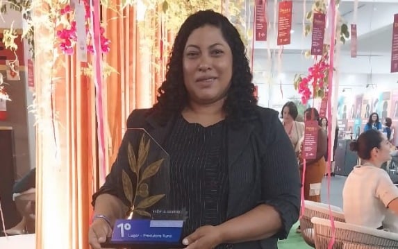 Mulher em pé segurando o troféu