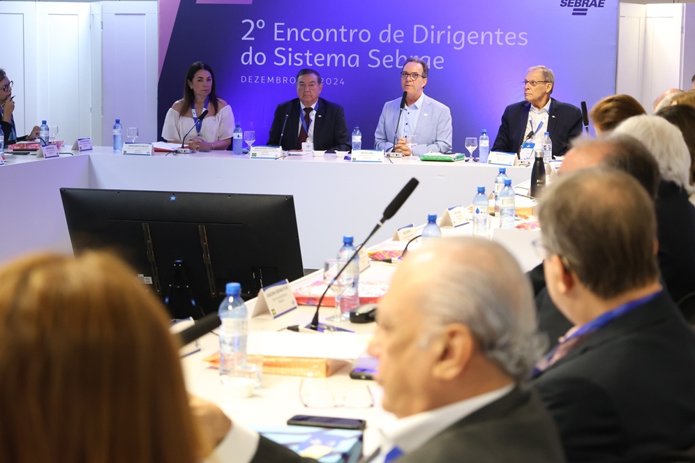 Pessoas sentadas em mesa de reunião para impulsionar empreendedorismo