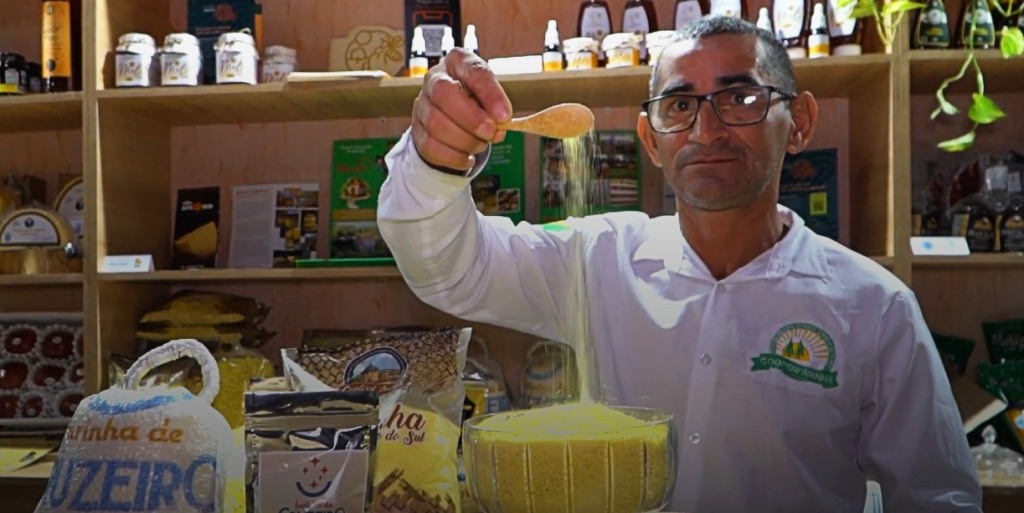 Um homem mostrando a farinha de mandioca do Cruzeiro do Sul, Acre