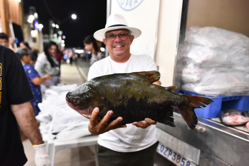 Homem segurando um peixe nas mãos