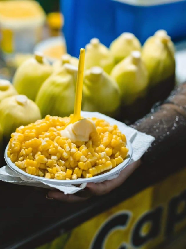 Pote de milho à frente e espigas em segundo plano