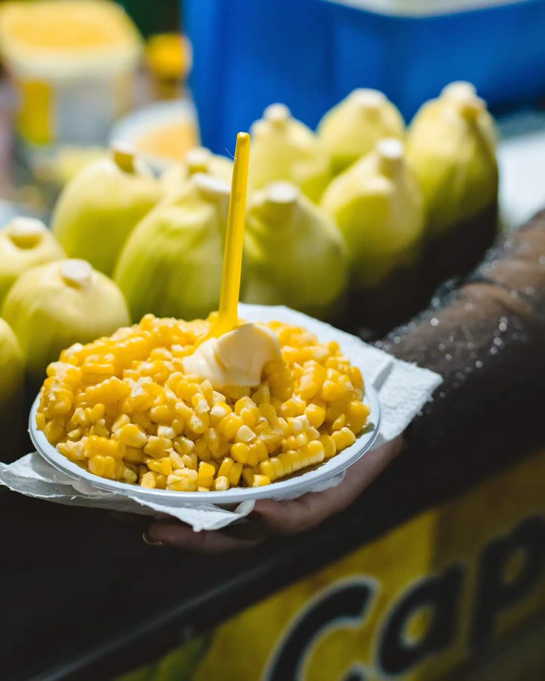 Pote de milho à frente e espigas em segundo plano