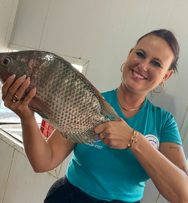 Uma mulher com um peixe nas mãos