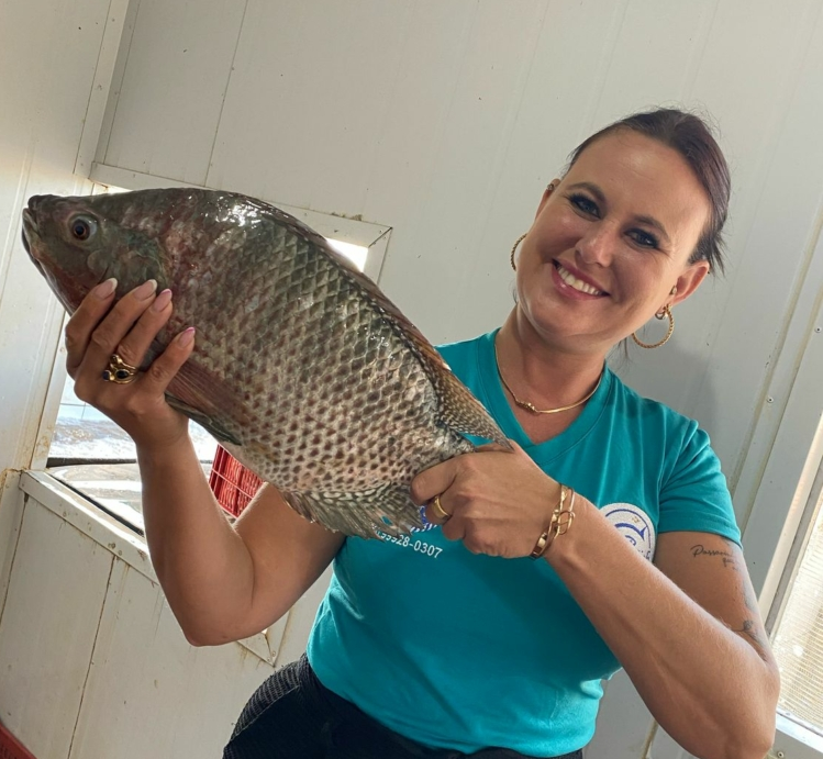 Uma mulher com um peixe nas mãos