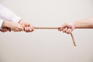 maõs puxando dois lados de uma corda, em disputa