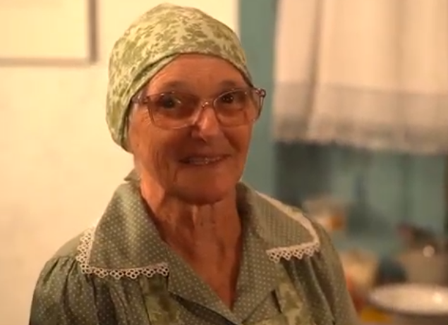 Uma senhora com lenço na cabeça. 