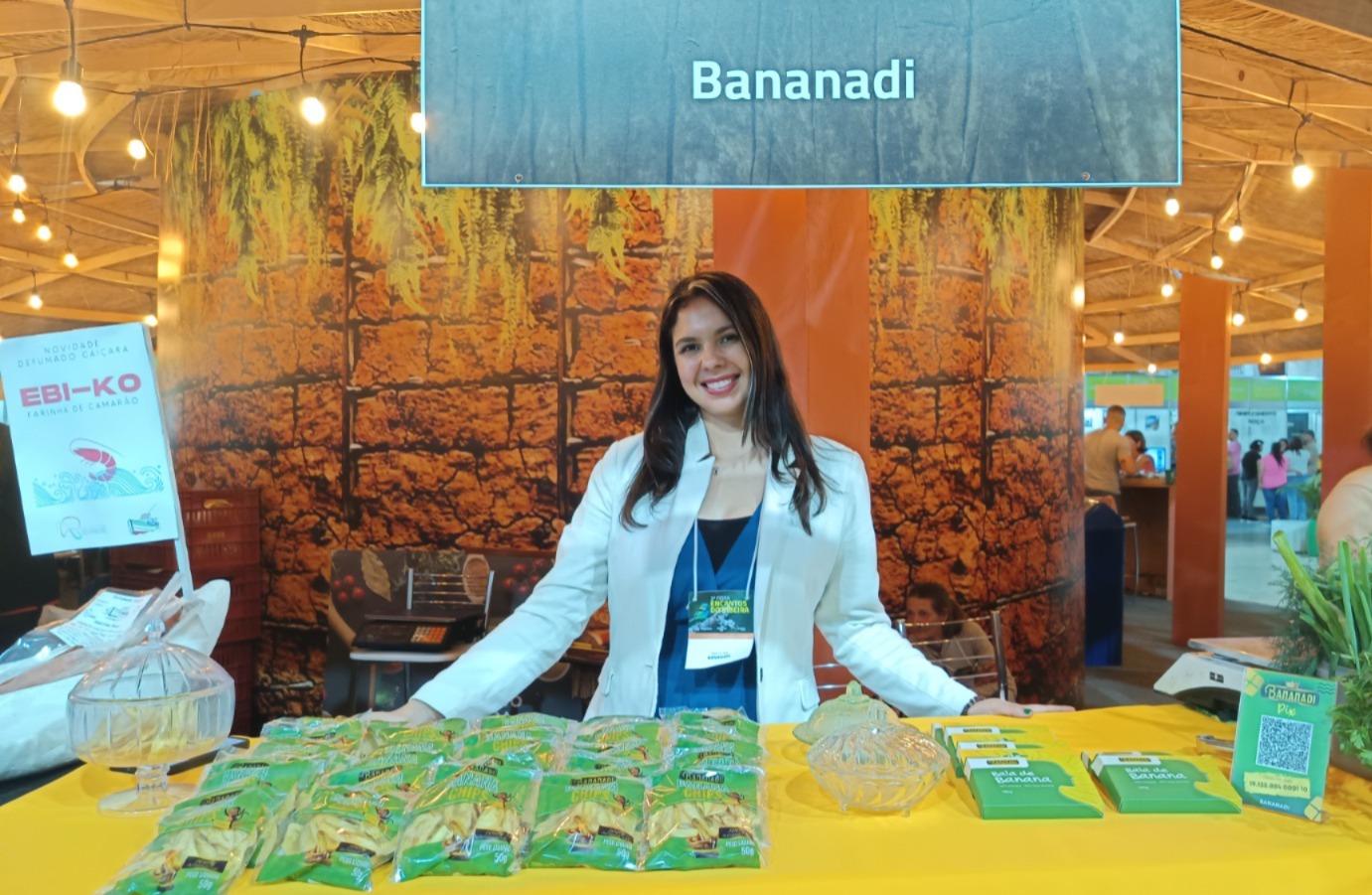 Na foto, aparece uma mulher apresentando os seus produtos à base de banana