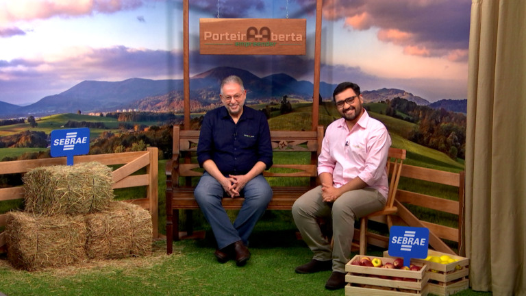 No cenário do programa Porteira Aberta Empreender, os apresentadores estão sentados e sorriem para a câmera.