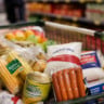 Imagem mostra carrinho de supermercado com comidas típicas de festa junina, como milho, salsicha e açúcar
