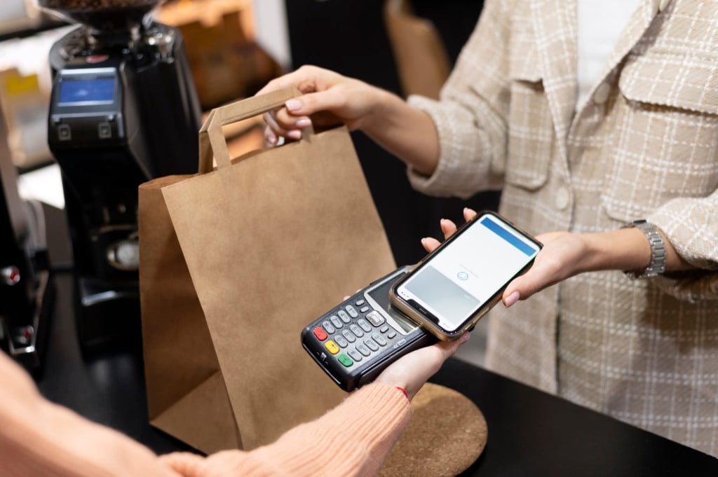 Imagem mostra pessoa usando o smartphone para pagar comprar; comércio, varejo Imagem mostra pessoa usando o smartphone para pagar comprar; comércio, varejo