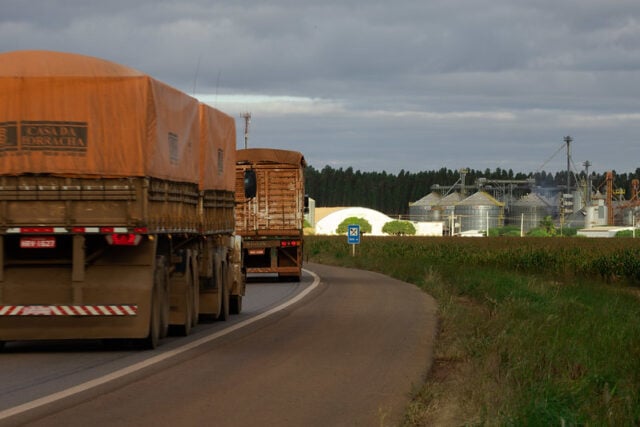 caminhão em estrada fazendo transporte de grãos para silo ou armazém de cooperativa