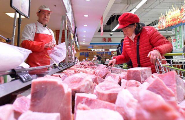 Uma mulher compra carne de porco em um supermercado em Nanchang, na Província de Jiangxi, leste da China, carnes