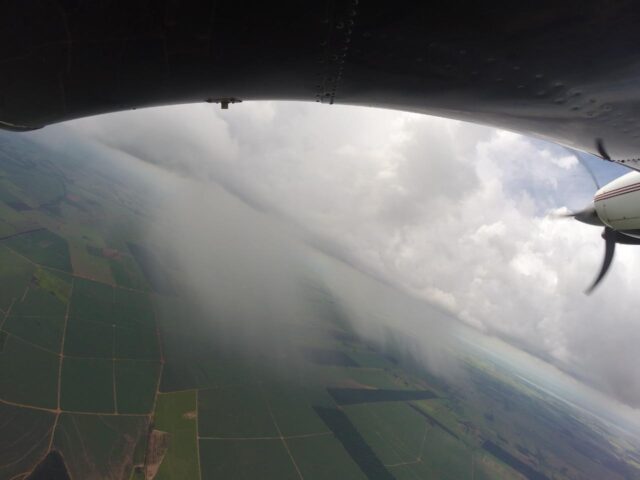 avião sobrevoando área agrícola para induzir chuva