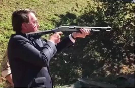 Jair Bolsonaro apontando arma